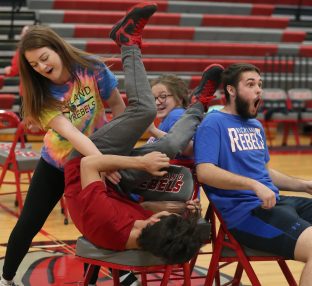 students at a pep assembly playing musical chairs