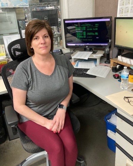 Ford sitting at her desk looking at the camera