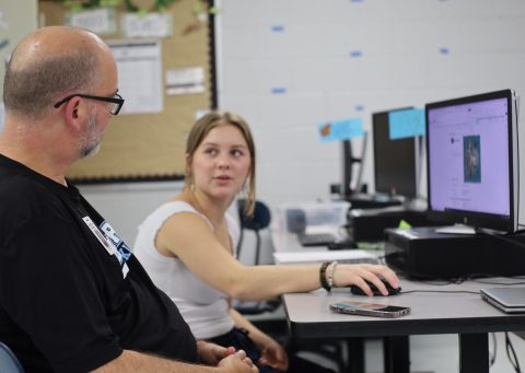 Brit Taylor working with a student on online yearbook design skills